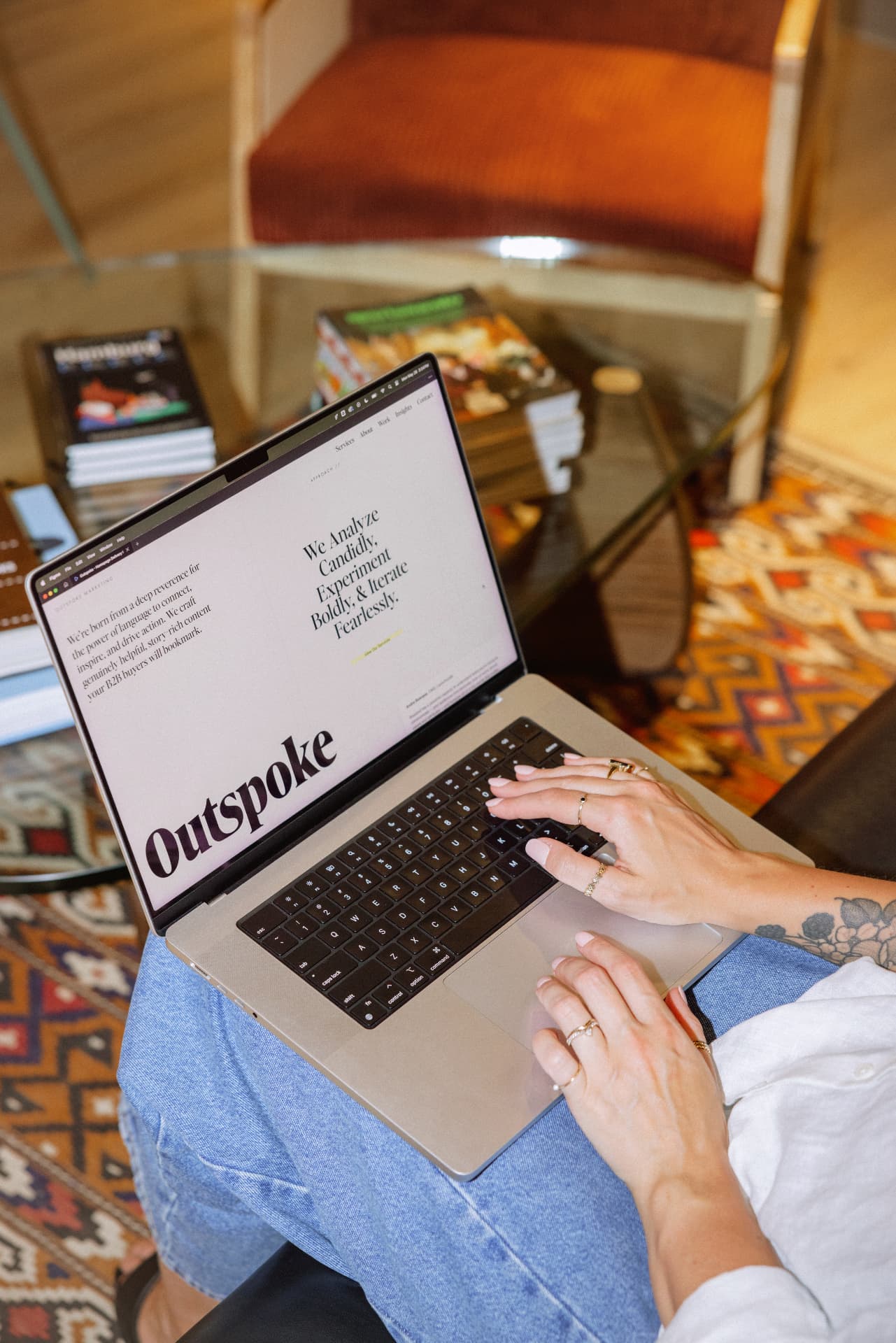 Rosalind working on a laptop displaying the Outspoke website